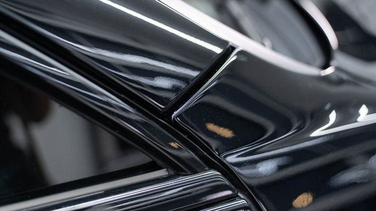 A close up of the side of a black car.