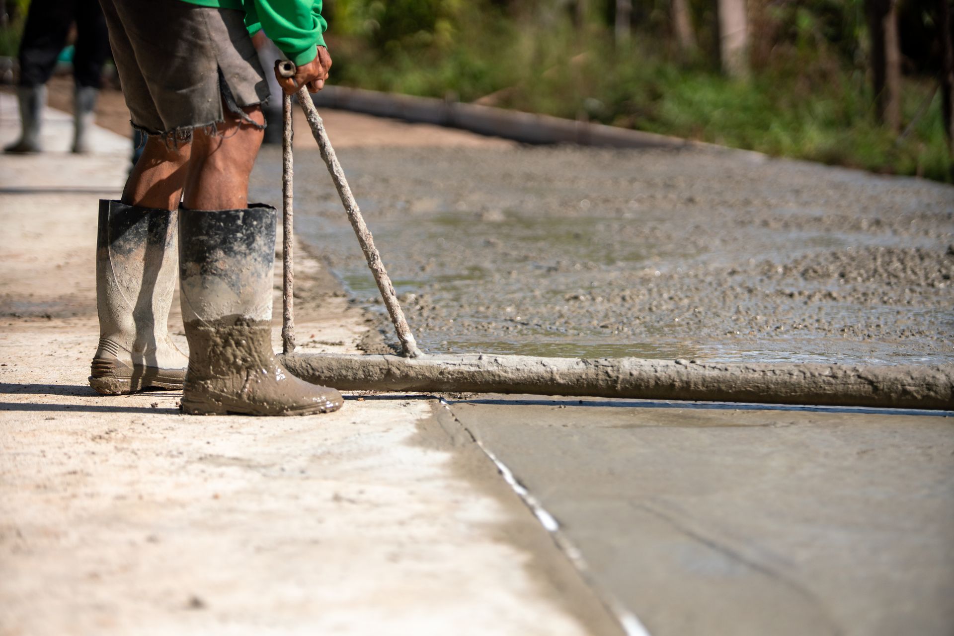 Concrete Driveways Contractor leveling wet cement on a residential driveway construction site. Home Concrete Contractor Parker CO