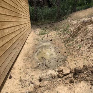 Puddle of Water Next to Wooden Building - Elizabeth, CO – NRK Skidsteer