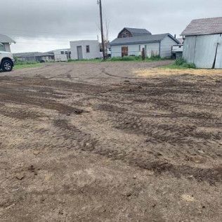 White Tuck Parked in Dirt Lot Next to House - Elizabeth, CO – NRK Skidsteer