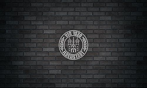 Eine schwarze Backsteinmauer mit einem Logo darauf.