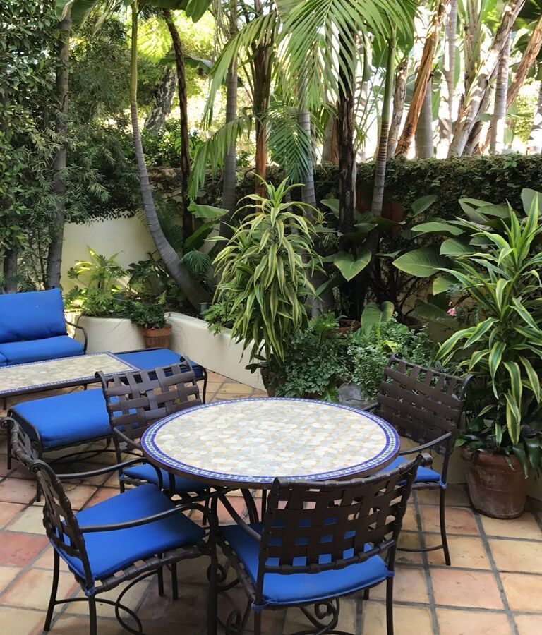 A patio with a table and chairs with blue cushions