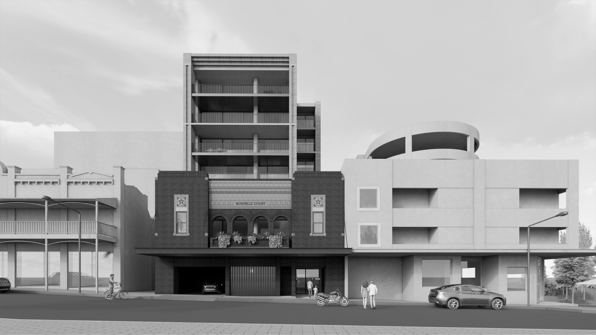 Black-and-white street view of modern buildings with parked cars and a few people on the sidewalk.