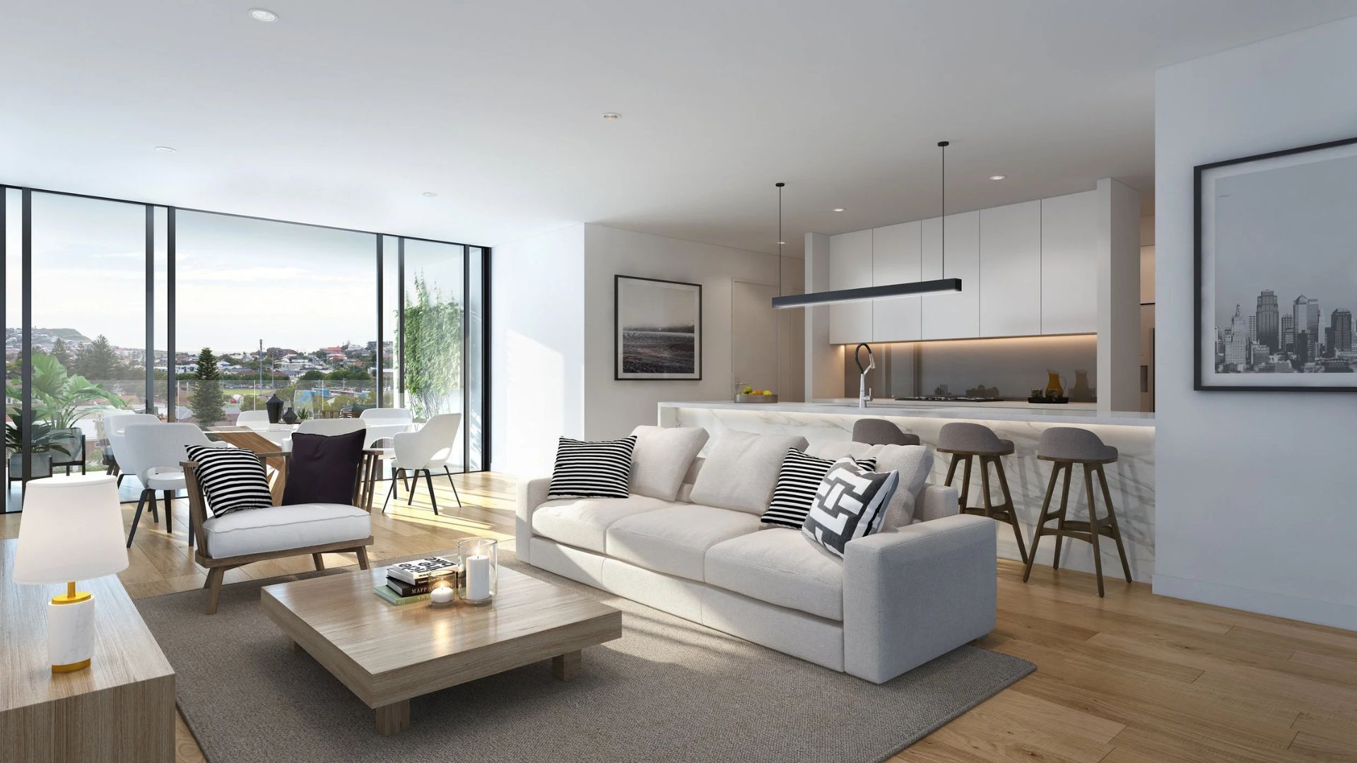 Bright modern open-plan living room with white sofa, wood floors, dining area, and kitchen island by large windows