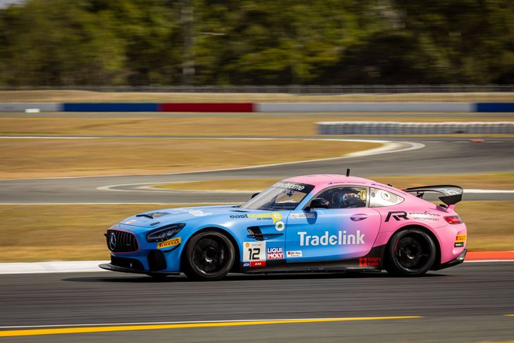 Blue and pink race car speeding on a track with blurred background and yellow lane markings