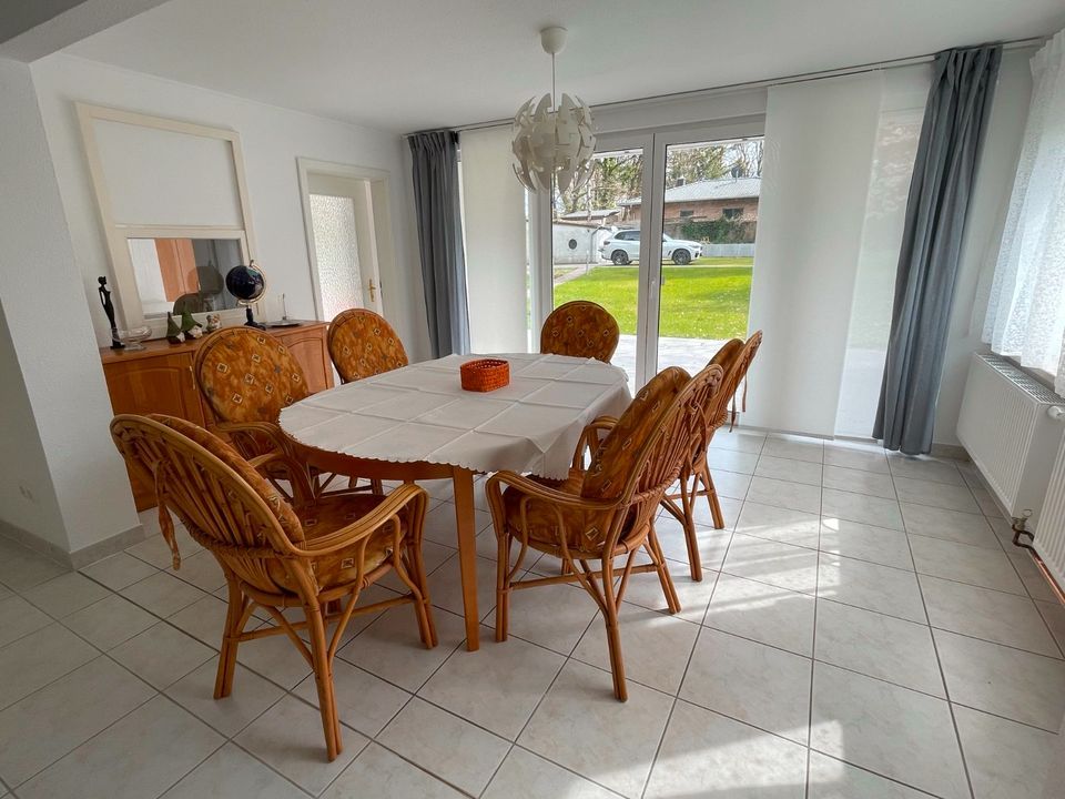 Ein Esszimmer mit Tisch und Stühlen und einer Glasschiebetür.