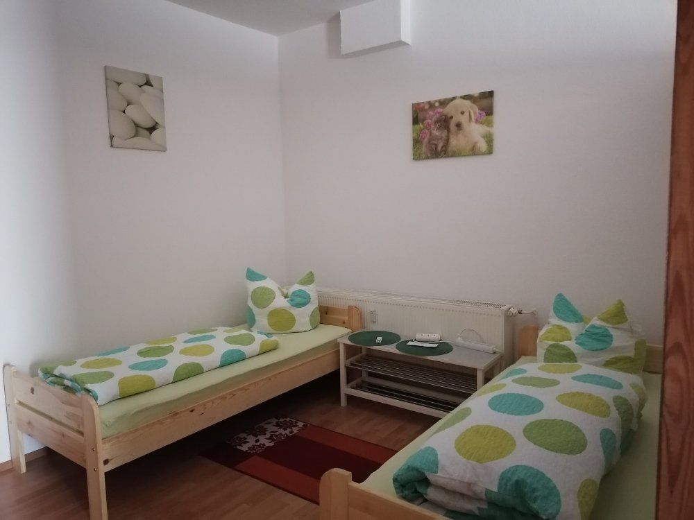 Ein Schlafzimmer mit zwei Betten und einem Hundebild an der Wand