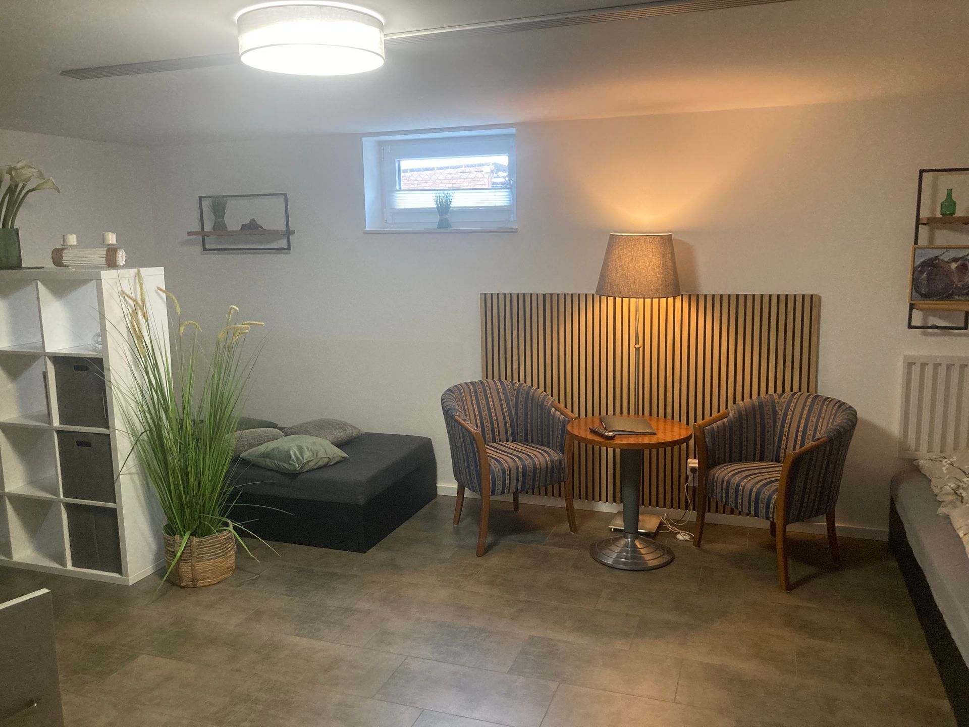 Ein Wohnzimmer mit zwei Stühlen, einem Tisch und einer Lampe.