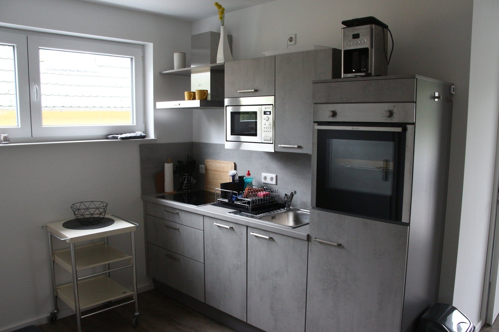 Eine Küche mit Herd, Backofen, Mikrowelle und Kaffeemaschine.