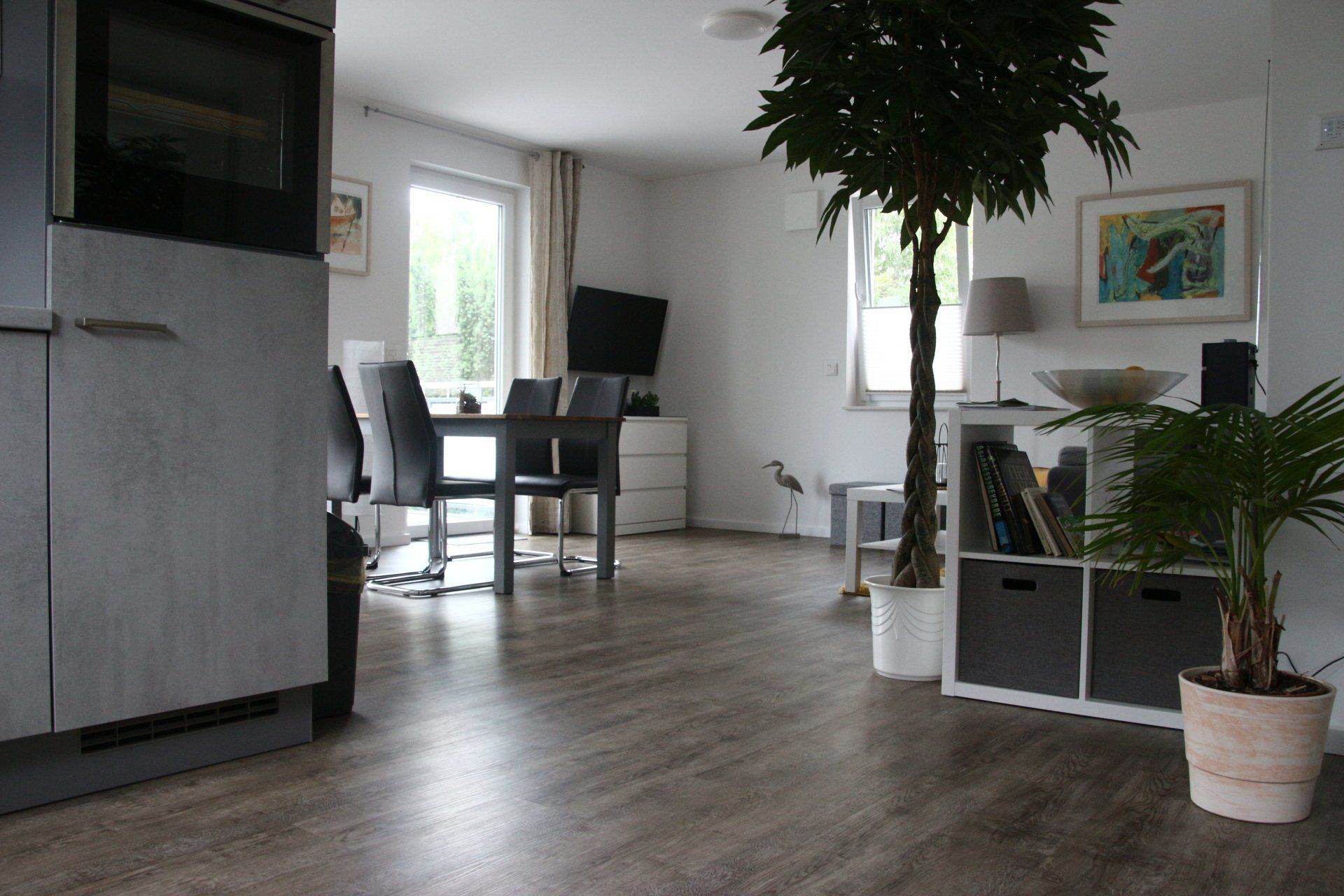 Ein Wohnzimmer mit Tisch und Stühlen und einer Topfpflanze