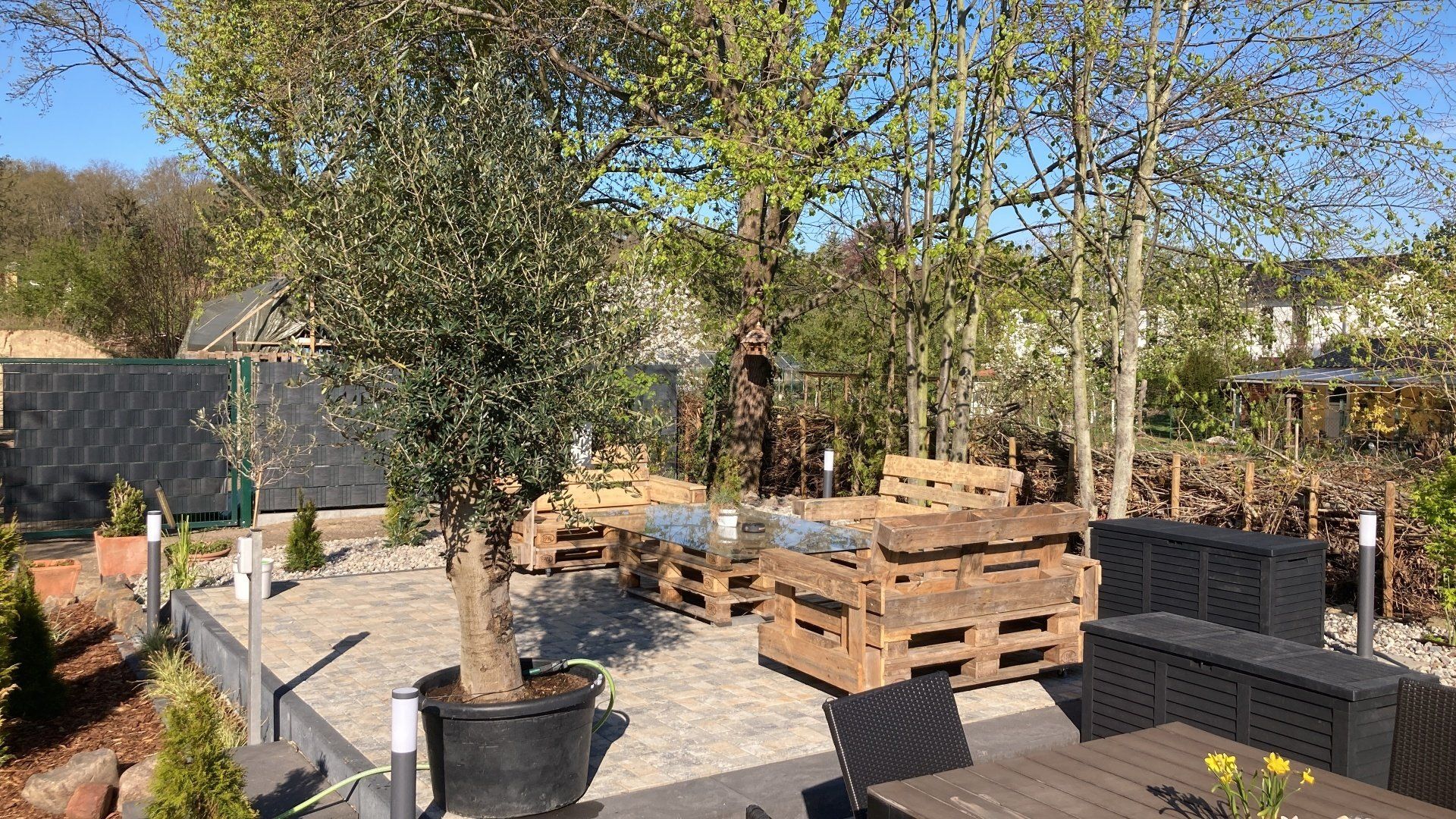 Eine Terrasse mit einem Tisch und Stühlen aus Holzpaletten.