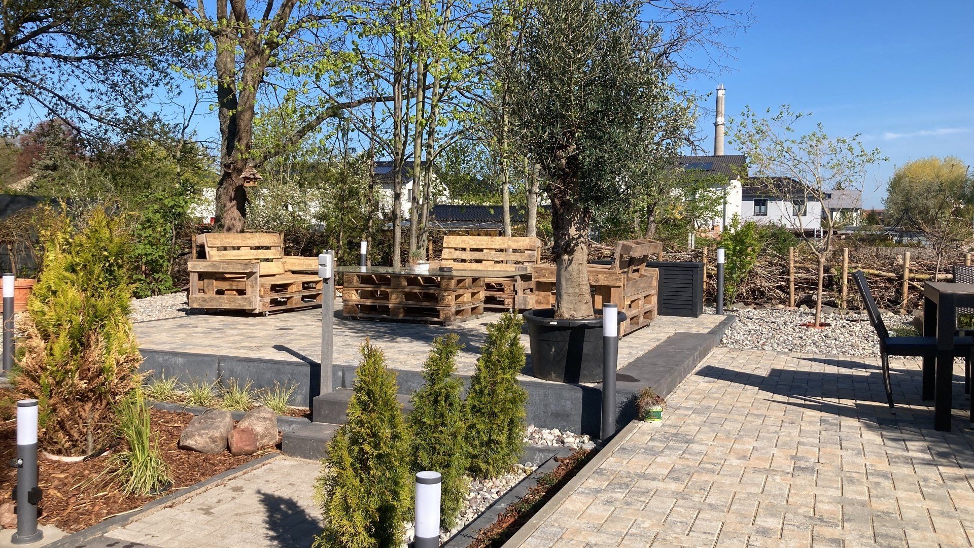 Eine Terrasse mit Tischen und Stühlen aus Holzpaletten.