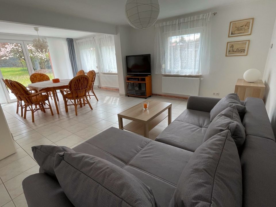 Ein Wohnzimmer mit Couch, Tisch und Stühlen.