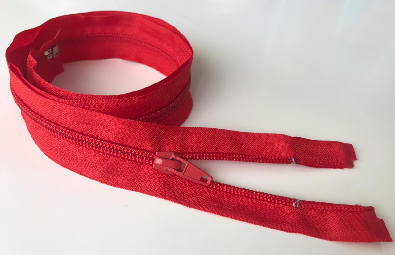 Red zipper coil on a white background, partially unzipped with the slider visible