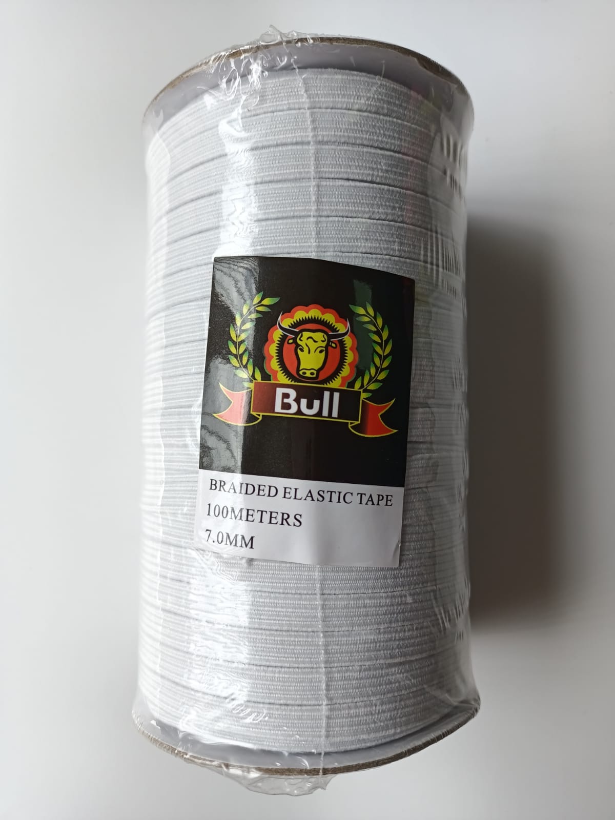 Silver cylindrical package with a black-and-red “Bull” label and handwritten tape markings on a white background