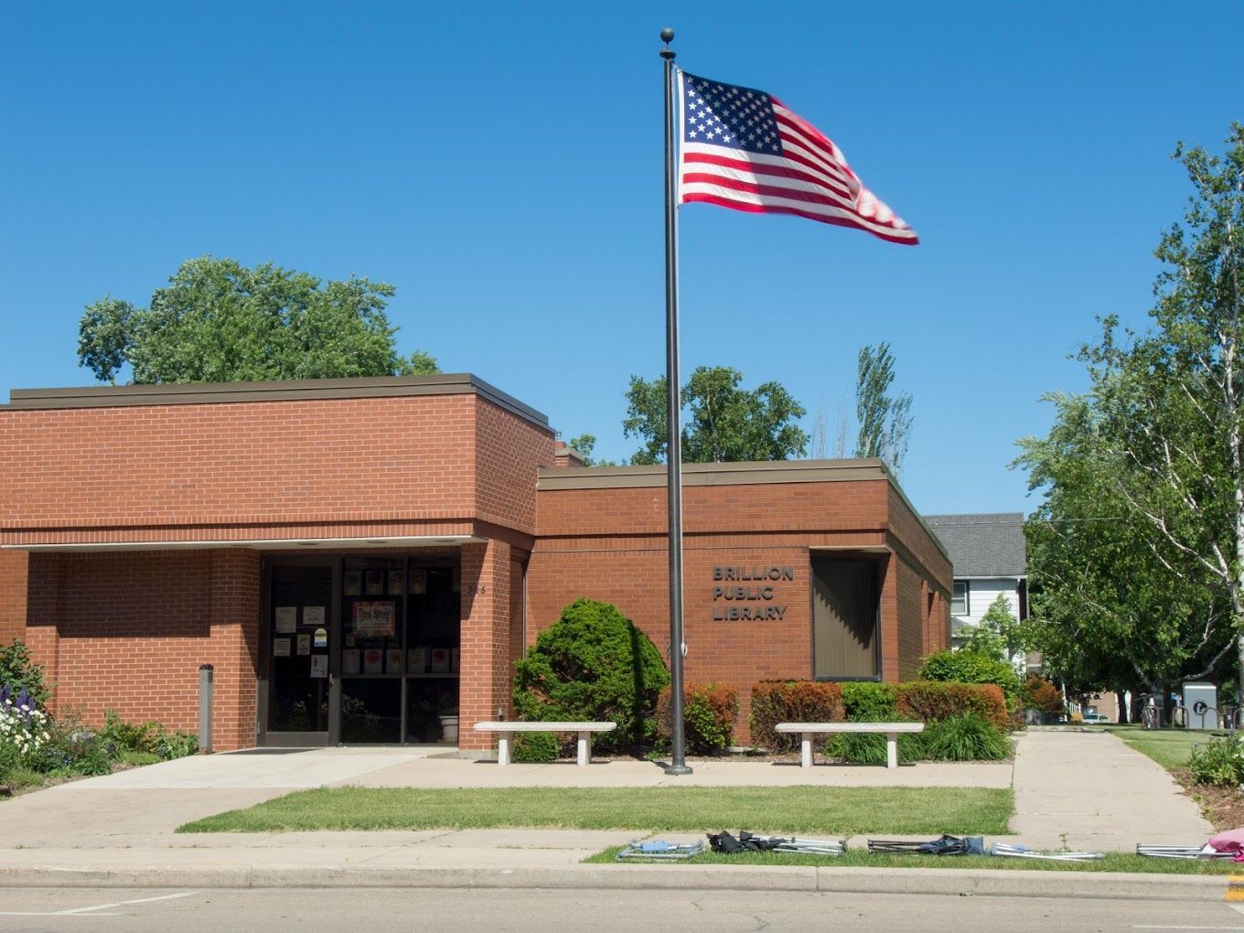 An american flag is flying in front of a brick building