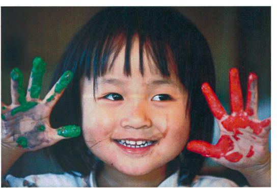 child with a green and red painted hand