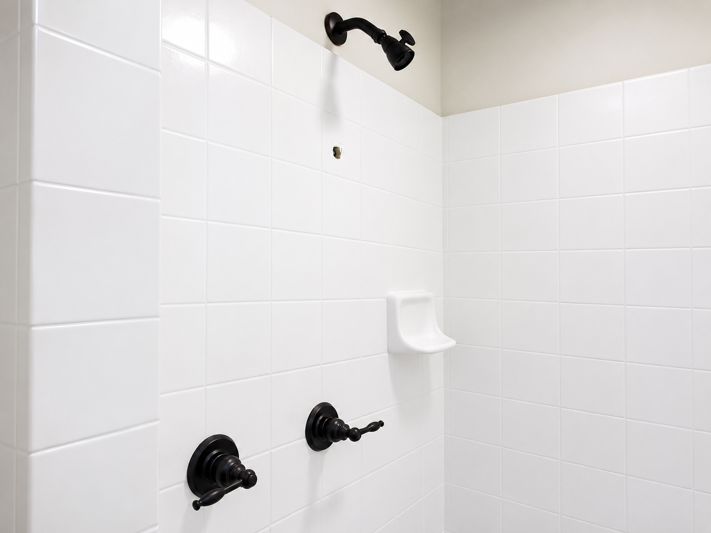 Hands repairing a chrome sink drain pipe under a white bathroom sink.