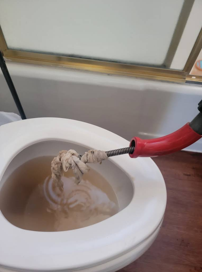 Person washing a stainless steel kitchen sink with pink gloves