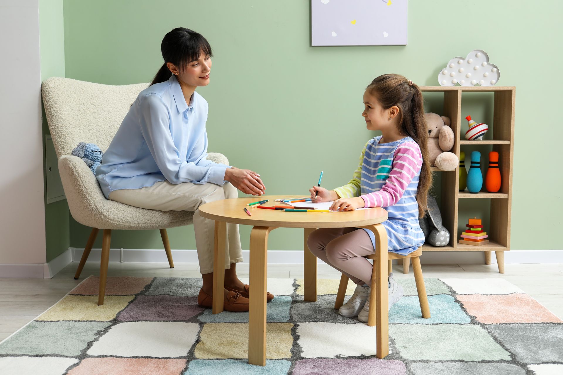Adult and child playing a board game at a small table in a bright living room