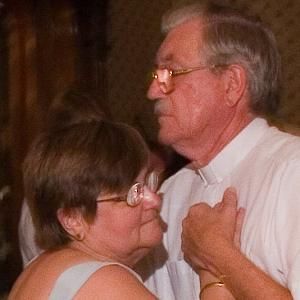 a man and a woman are dancing together and the woman is wearing glasses .