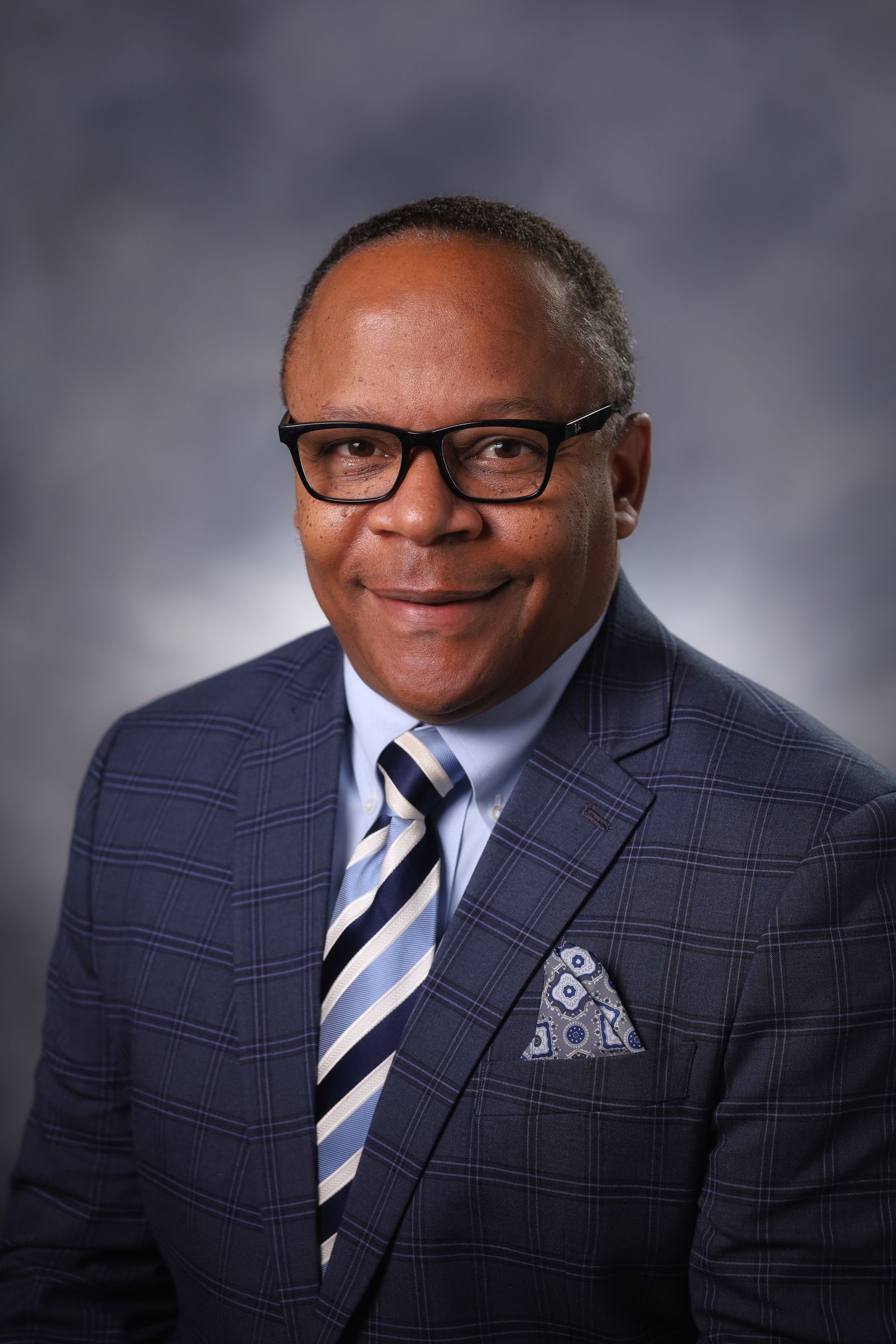A man in a suit and tie is smiling for the camera.