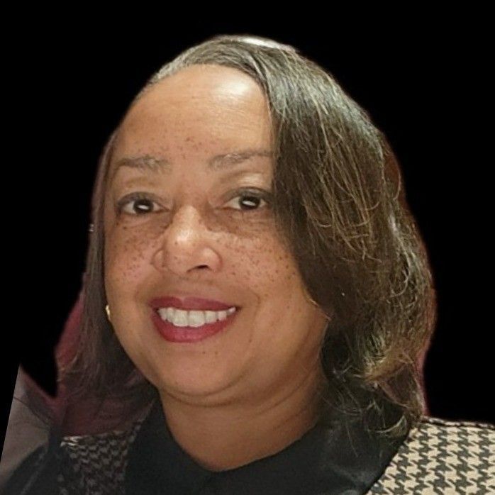 A woman is smiling for the camera with a black background.