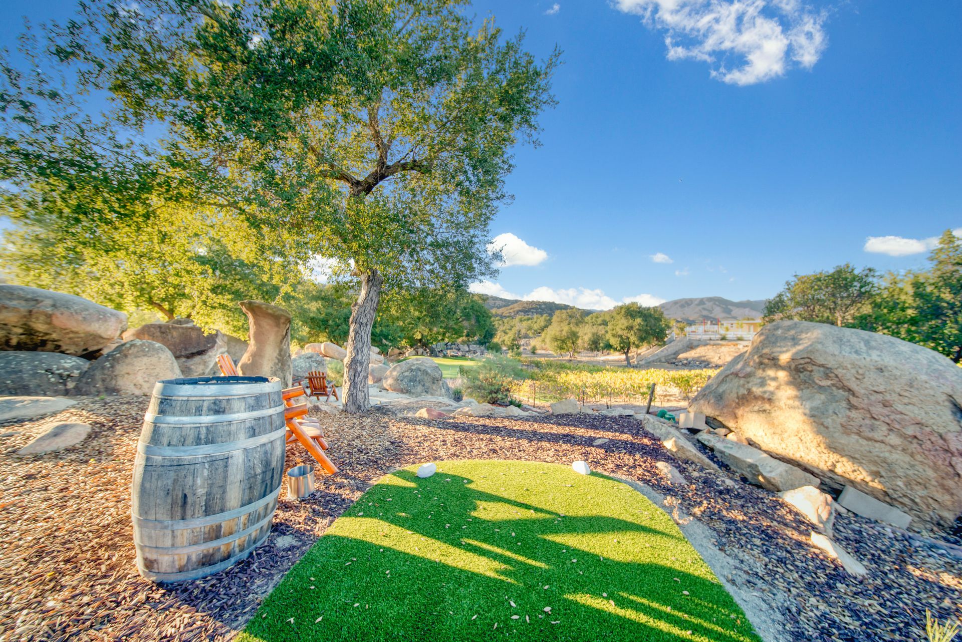 A barrel is sitting on top of a lush green field.