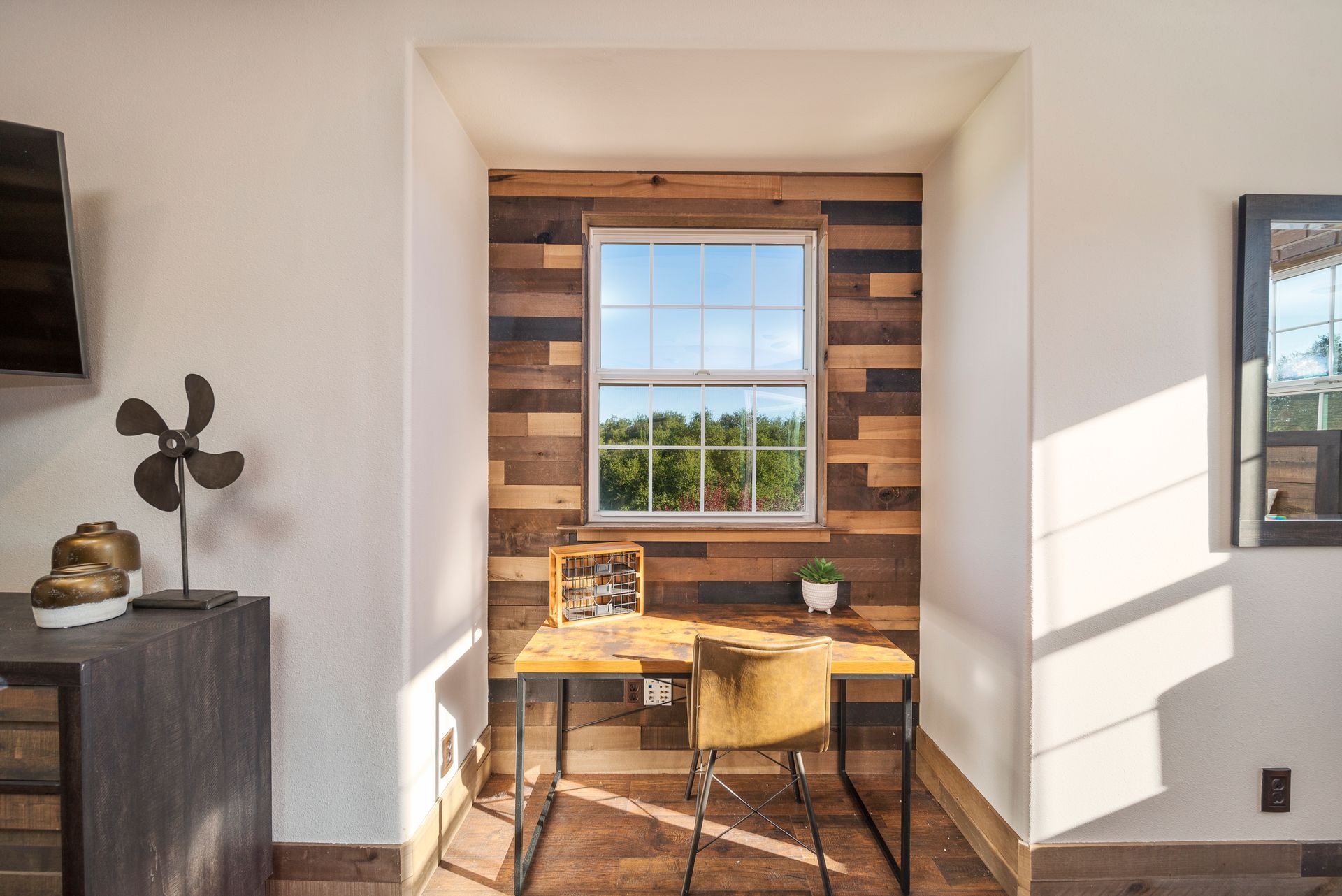 Small desk nook with a window seat, wood accents, and a chair in a bright room