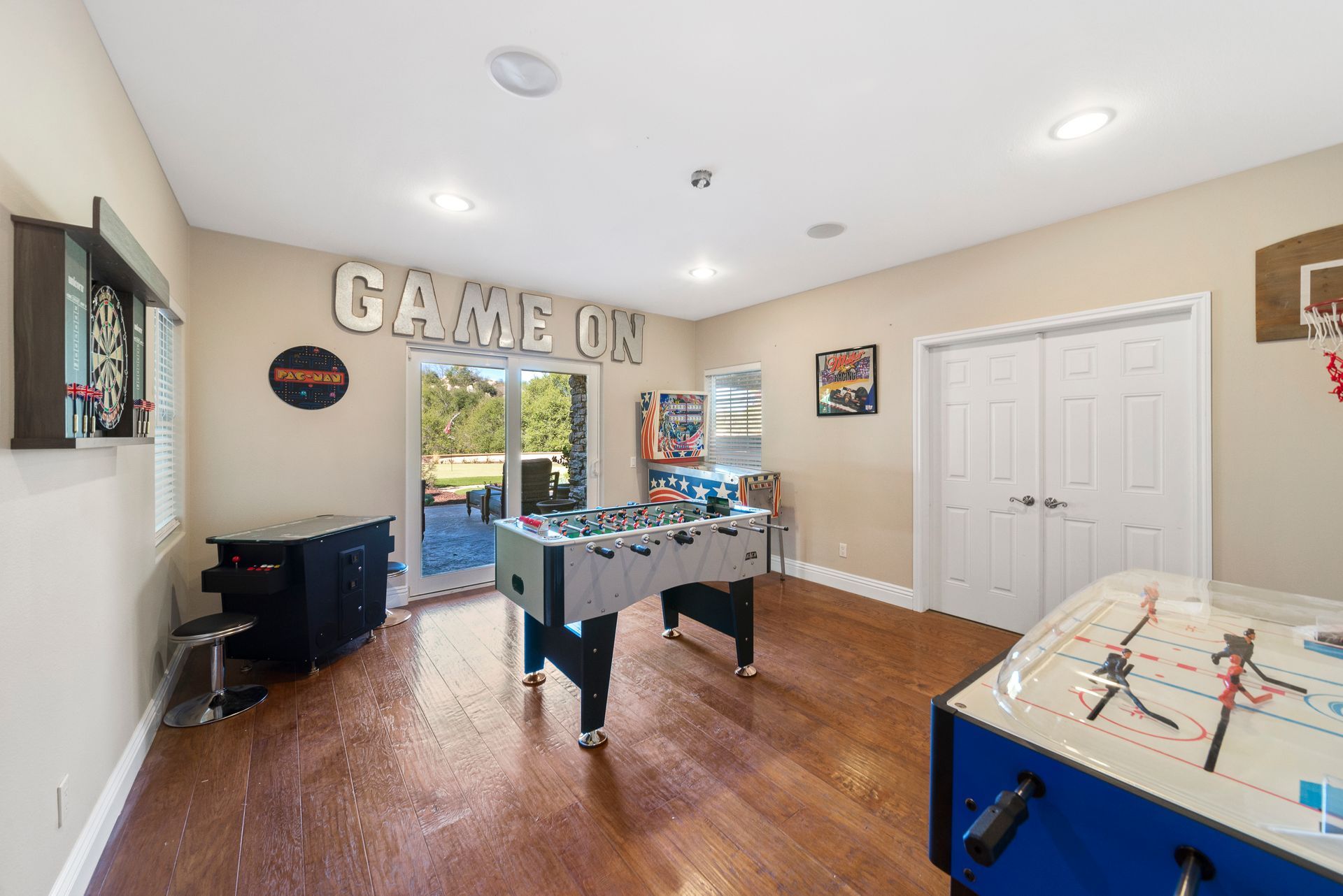 a game room with two pool tables and a basketball hoop.