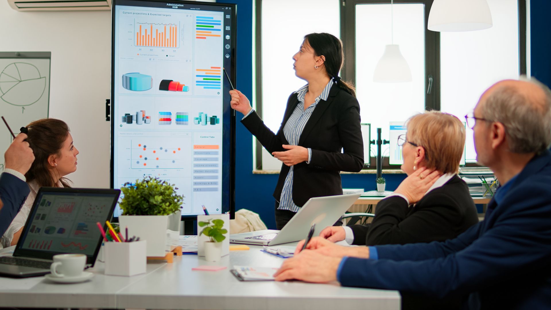 a woman is giving a presentation to a group of people in a conference room .