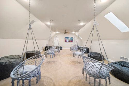A room with a lot of chairs hanging from the ceiling.
