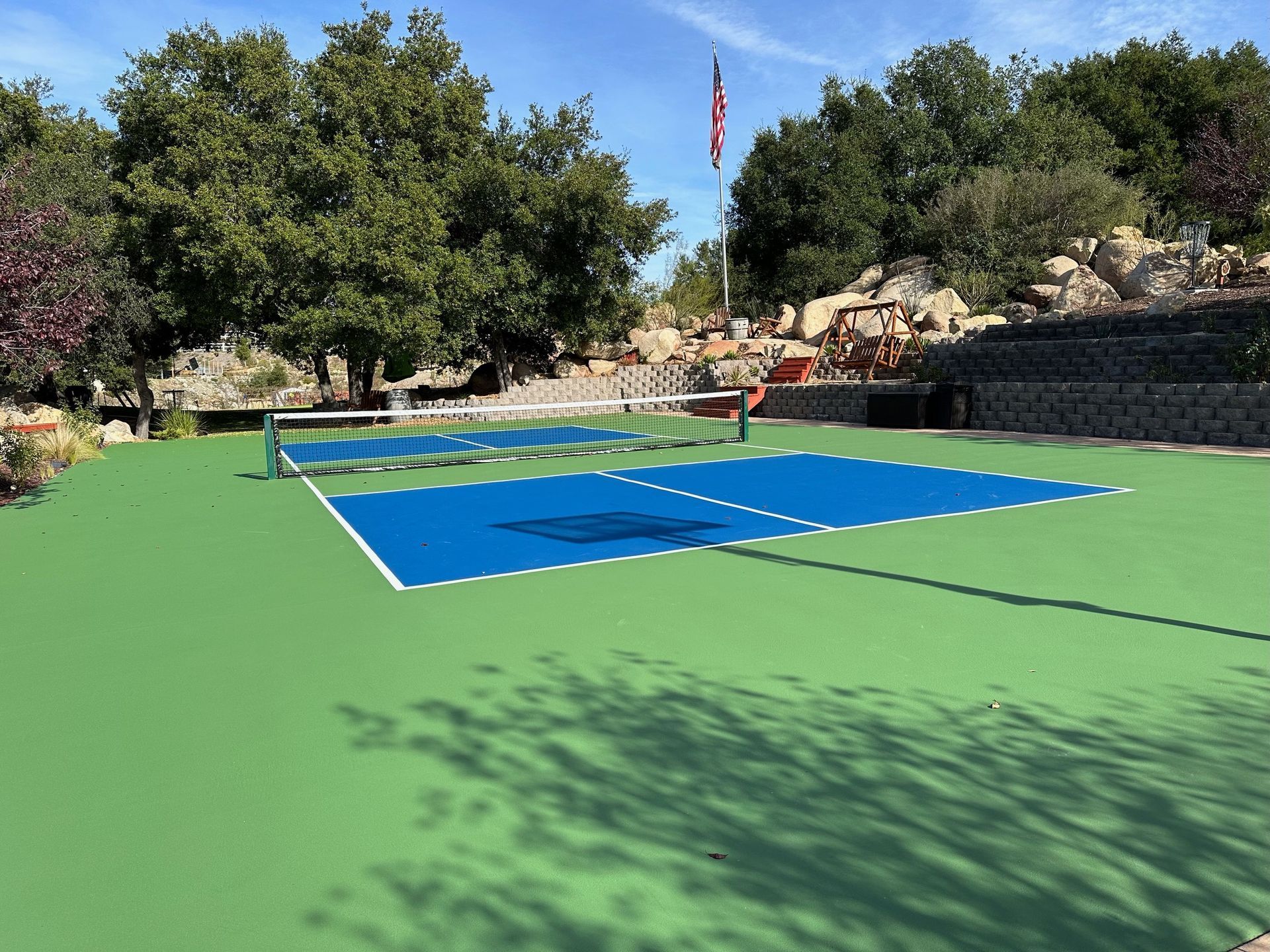 a tennis court with a flag in the background