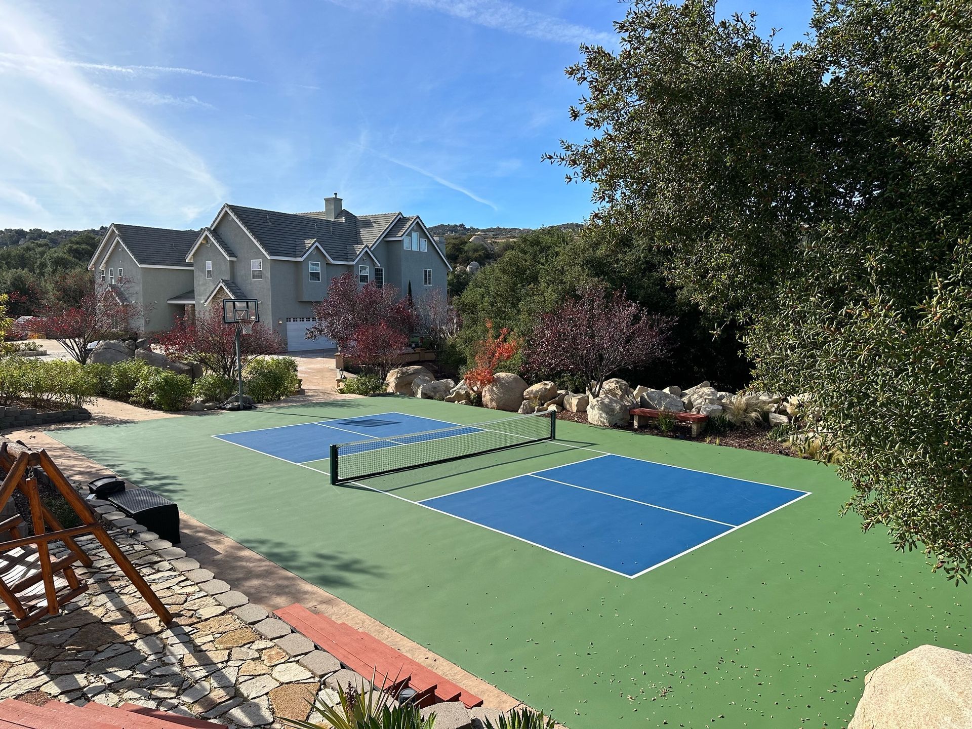 a pickleball court with a large house in the background a pickleball court with a large house in the background