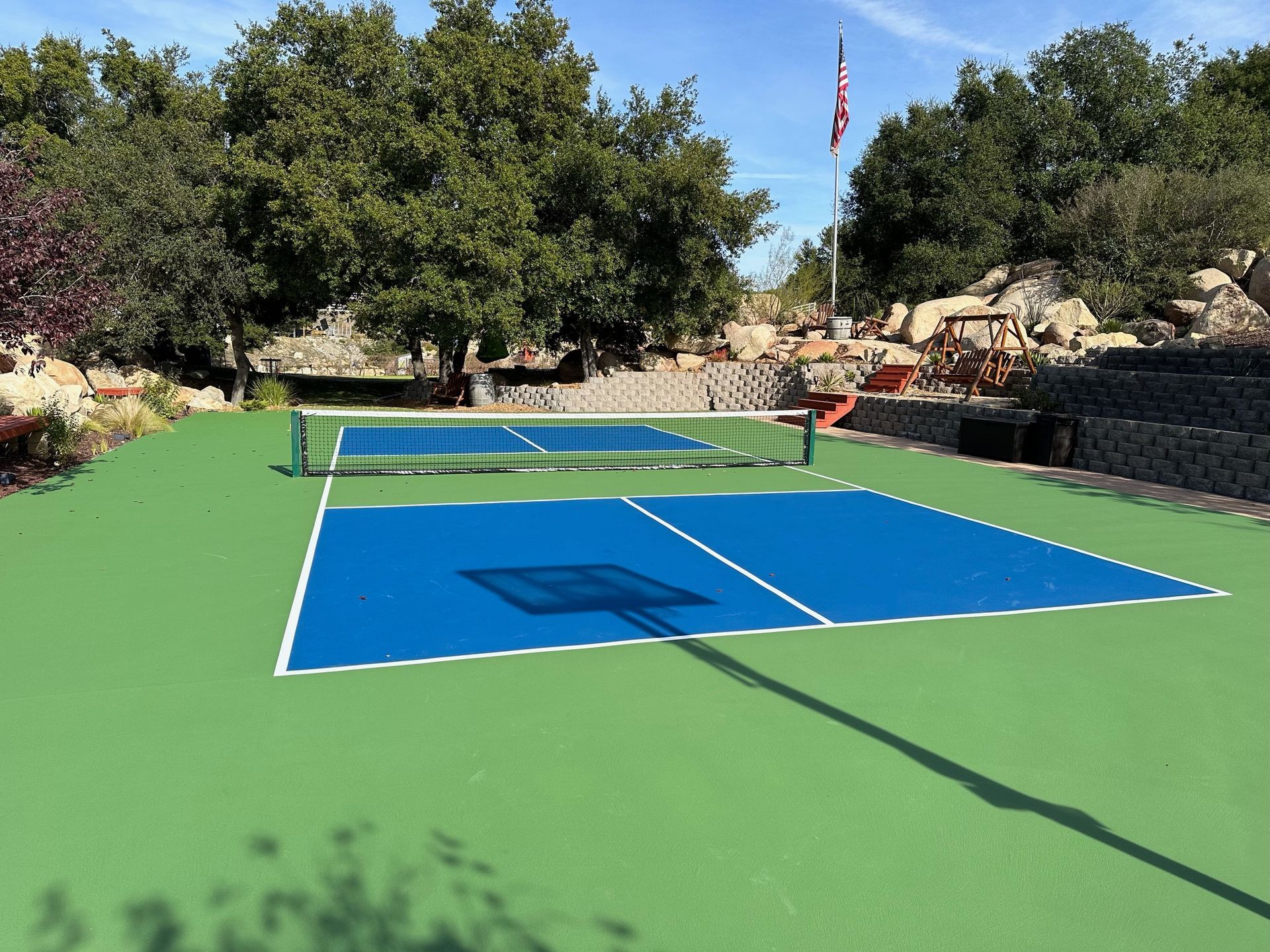 a pickleball court with a flag in the background