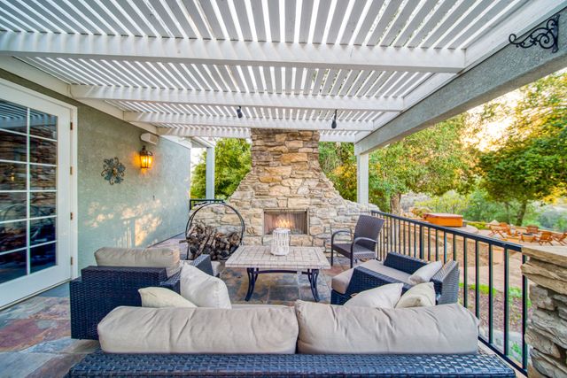 A large swimming pool surrounded by chairs and a pergola.
