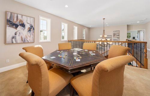 a dining room with a table and chairs and a painting on the wall.