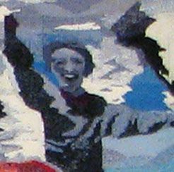 Smiling person with raised arms in a snowy scene, with blue sky and dark trees in the background