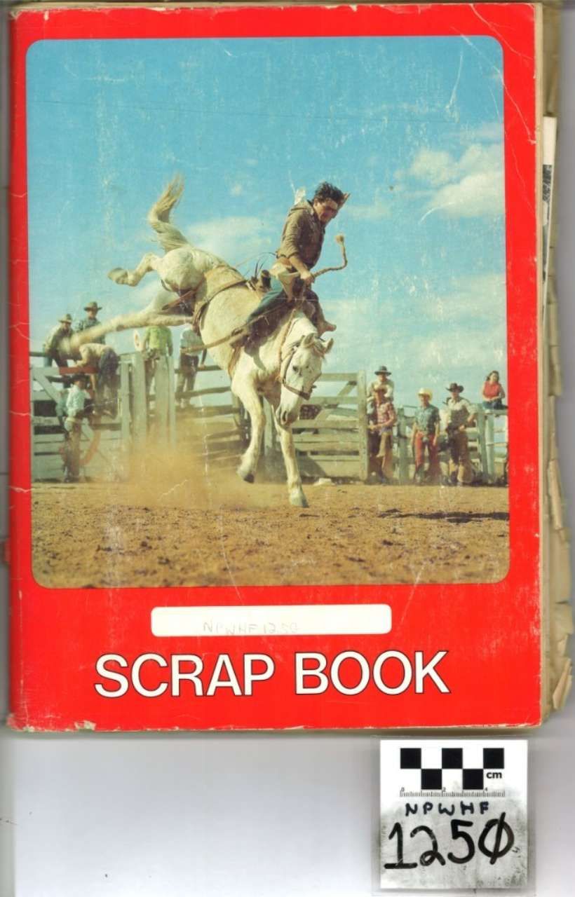 Red scrapbook cover with a rodeo rider on a bucking horse and the words “SCRAP BOOK” at the bottom