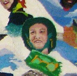 Cartoon child’s face in a green hood among blue and white abstract shapes