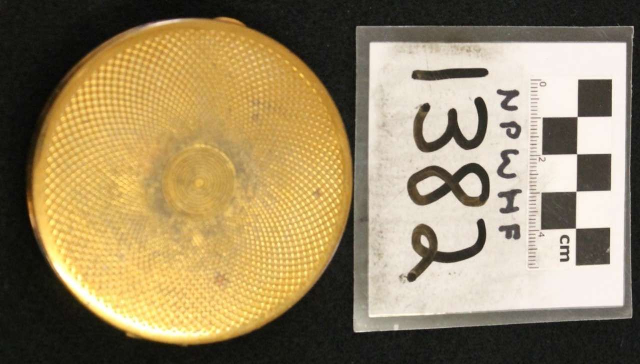 Yellow circular textured object beside a numbered evidence marker card on a dark background