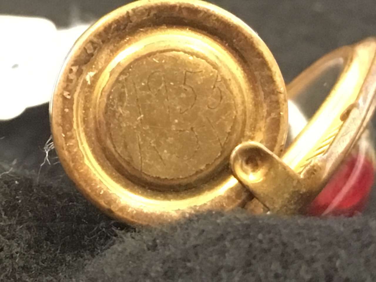 Close-up of a gold metal clasp or ring on a black and red surface