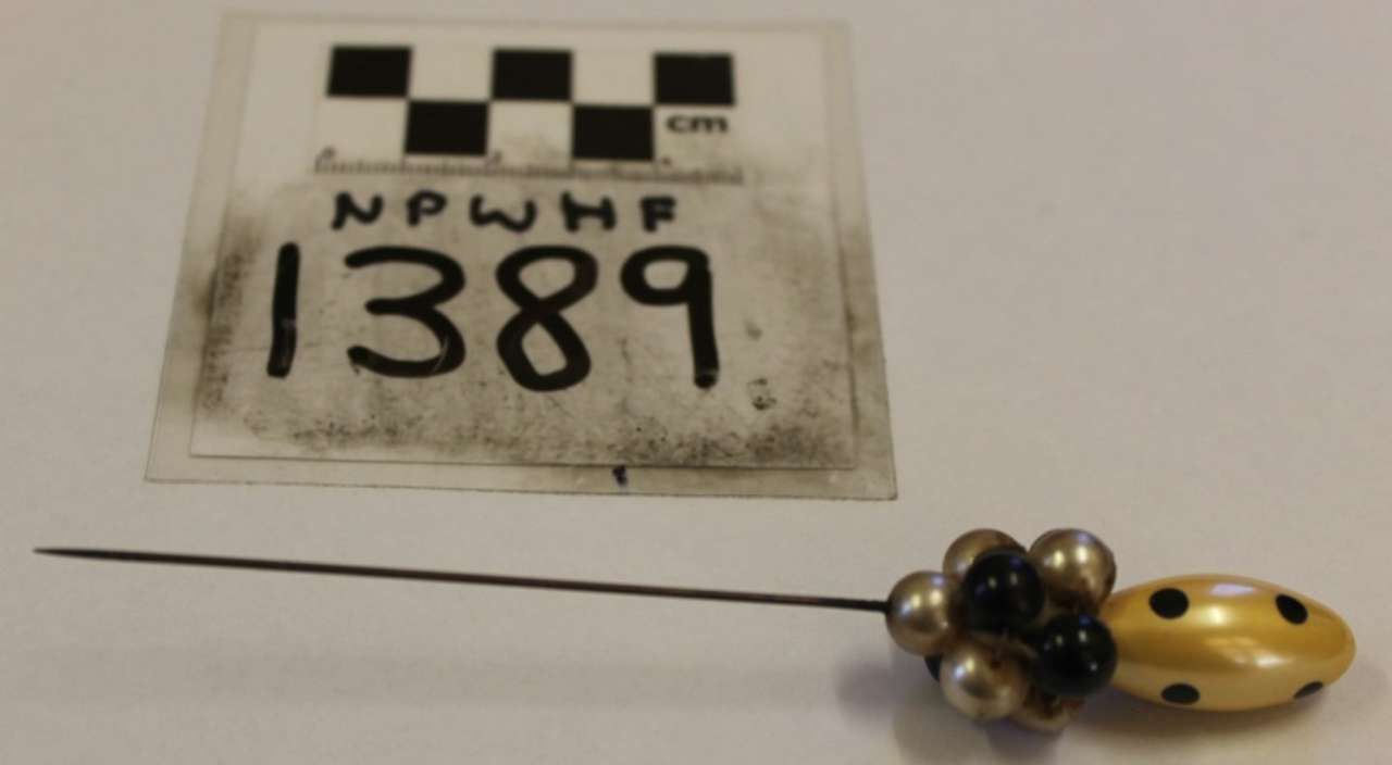 Numbered evidence tag beside a small yellow-and-black tool or object with a metal rod.