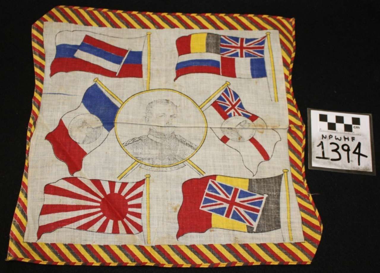 Embroidered flag quilt with multiple national flags and a central portrait, on a dark background