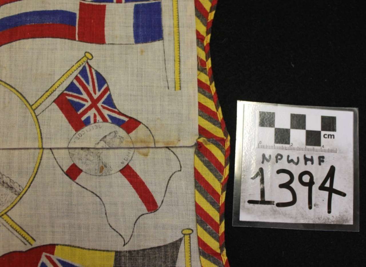 Close-up of a fabric flag patch with Union Jack and red-and-white emblems beside a numbered label, 1394