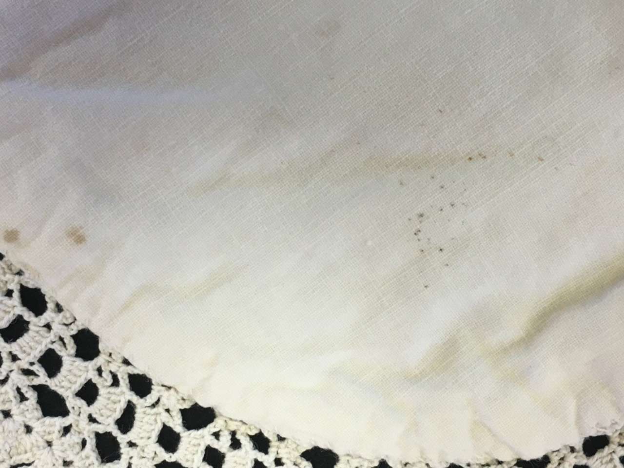 White fabric with a lace border and a few small stains.