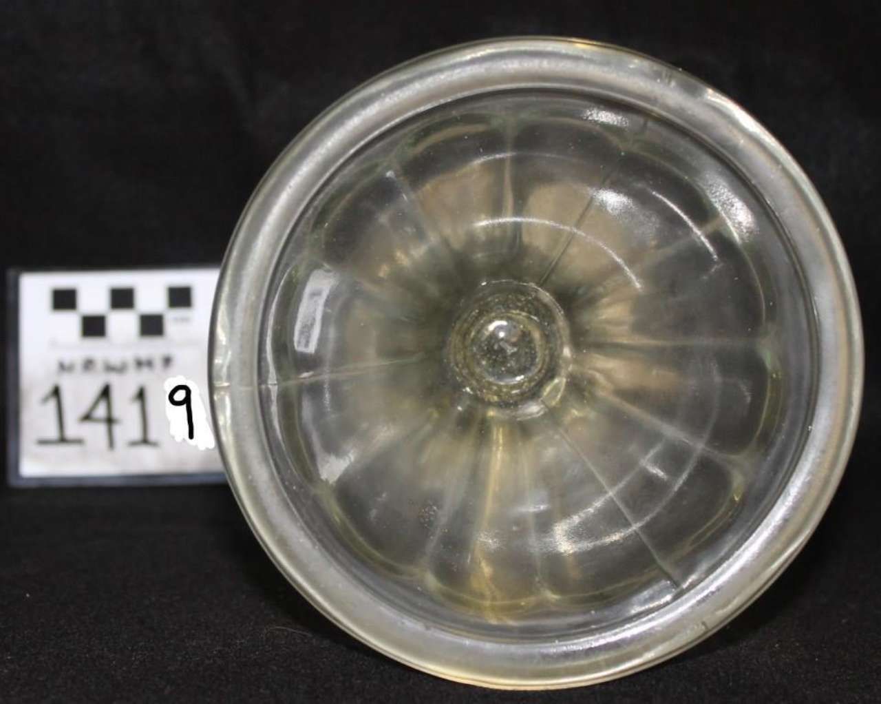 Top view of a clear glass cup or jar with a black-and-white label marked 1419 beside it.