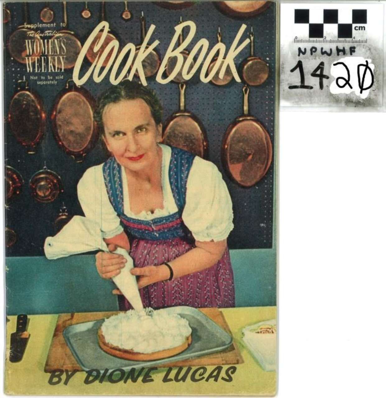 Vintage cookbook cover showing a smiling woman mixing batter in a kitchen, with hanging pans and “Cook Book” title.