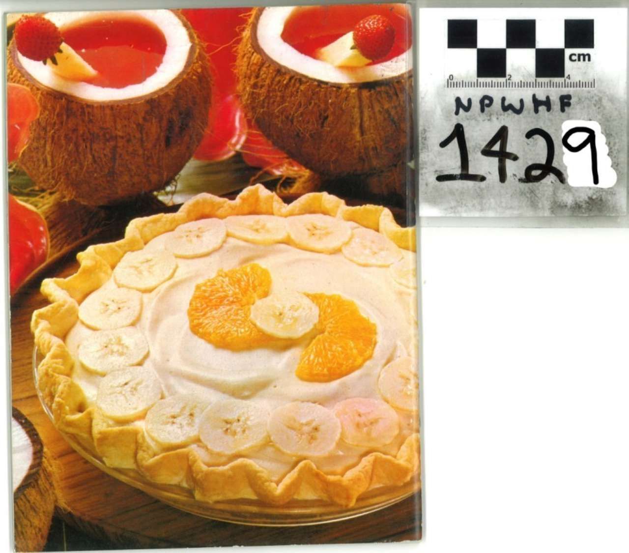 Dessert pies, including a coconut cream pie topped with orange slices and two red-topped pies.