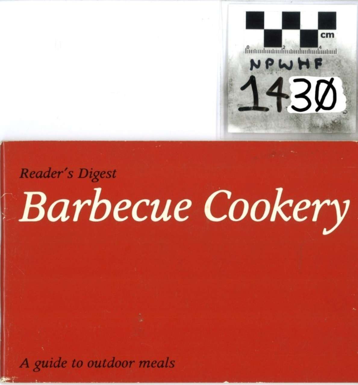 Red Reader’s Digest “Barbecue Cookery” book cover with a small label above it